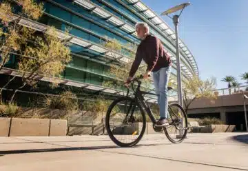man in red long sleeve shirt and blue denim jeans riding on bicycle