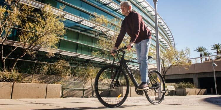 man in red long sleeve shirt and blue denim jeans riding on bicycle